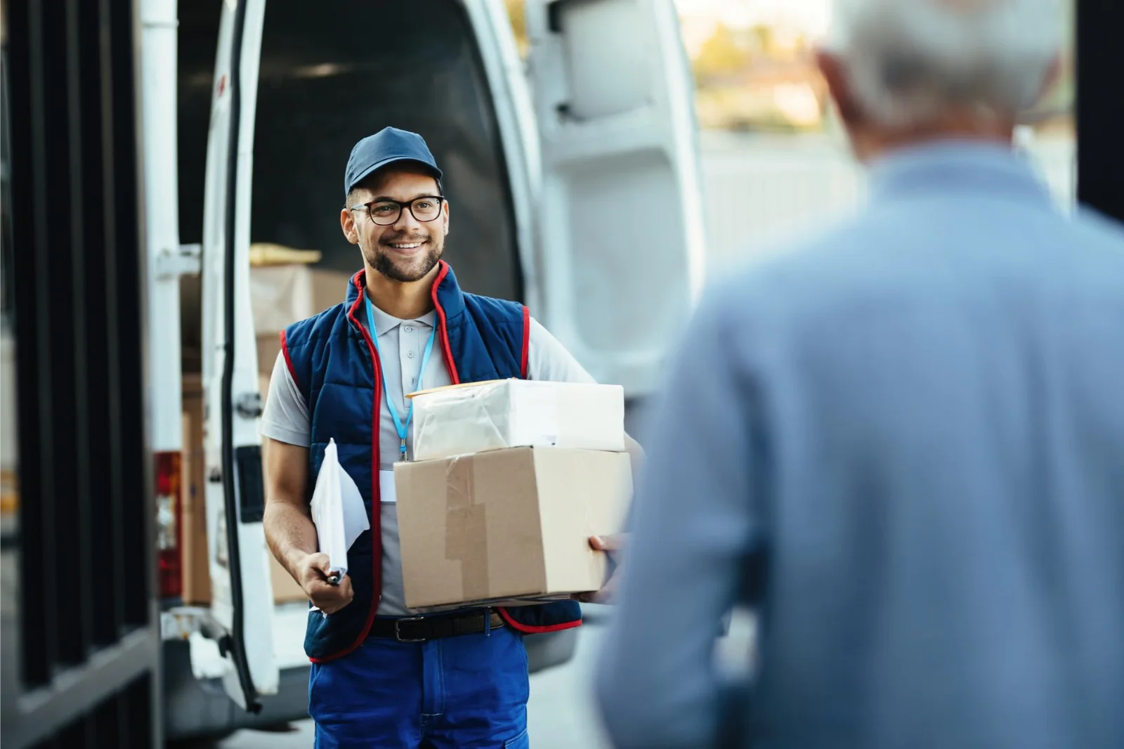 A MULTiiS courier handing a parcel to a customer at the van